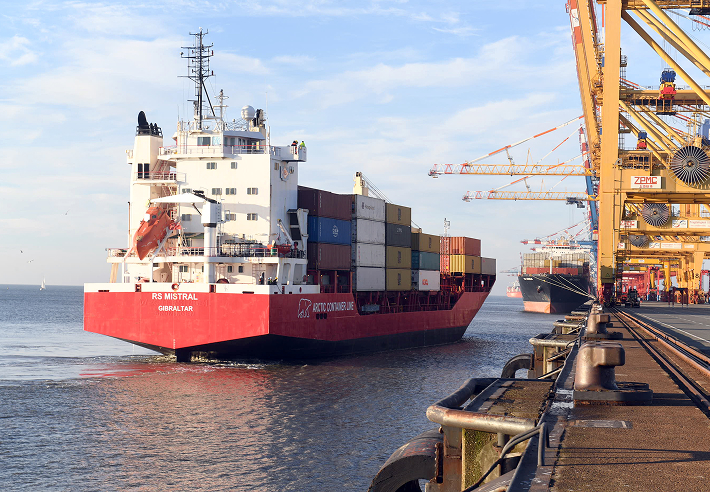 Containerschiff beim Anlegen in den Hafen