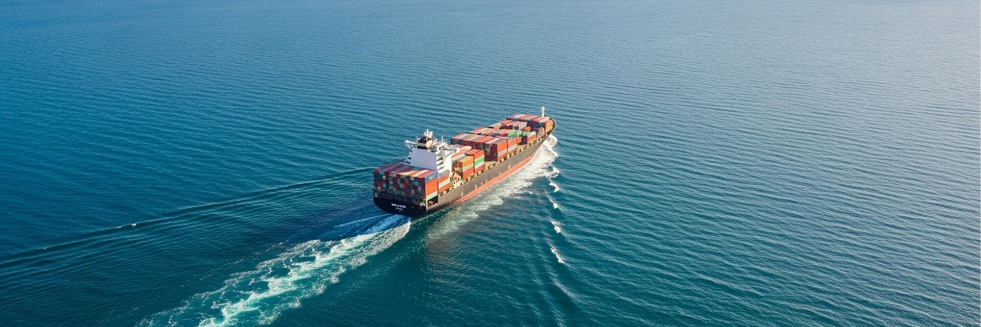 Containerschiff von schräg oben auf offenem Meer